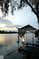 A woman standing on a dock next to a body of water.