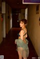 A woman in a blue lingerie standing in a hallway.